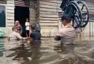 Beri Bantuan Kursi Roda ke Penyandang Disabilitas, Iptu Kaban Menerobos Banjir Setinggi Dada Orang Dewasa - JPNN.com
