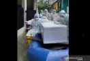 Polisi Evakuasi dan Makamkan Jenazah Pasien Covid-19 yang Terjebak Banjir - JPNN.com