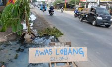 Jalan Rusak Berlubang, Warga Pasang Tanda Peringatan Seadanya