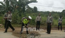 Lihatlah, Polisi Gotong Royong Memperbaiki Jalan - JPNN.com
