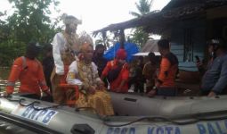 Lihat, Pengantin Baru Naik Perahu Karet di Tengah Banjir - JPNN.com