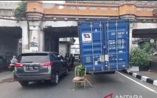 Truk Kontainer Bermuatan Karpet Tersangkut di Kolong Jembatan Rel Kereta Matraman - JPNN.com