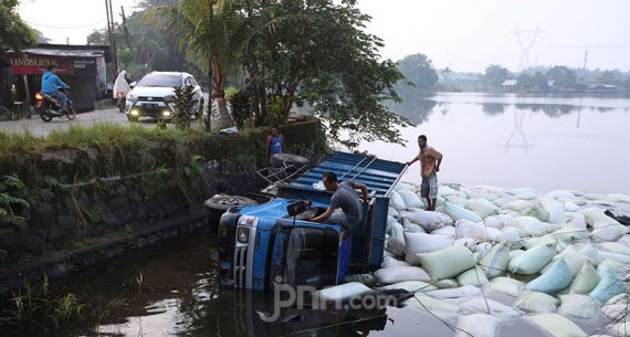 Gara-gara Mengantuk, Truk Sekam Terjun ke Setu - JPNN.com