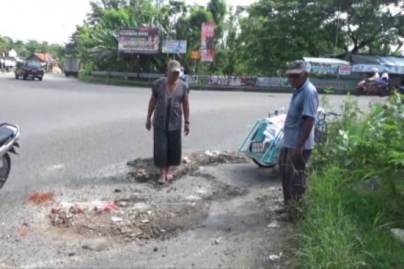 Pemerintah ke Mana? Kok Tukang Becak Perbaiki Jalan - JPNN.COM