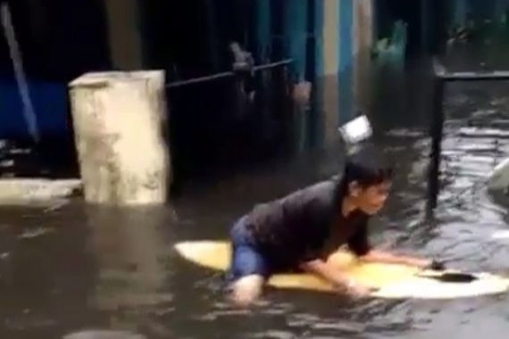 Mantap Jiwa! Seorang Ibu Main Papan Selancar di Tengah Banjir Padang - JPNN.COM