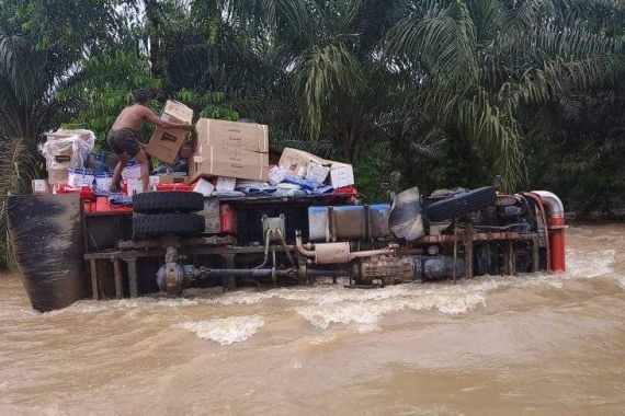 Nekat Menerjang Banjir, Truk Sembako Terguling, Lihat - JPNN.COM