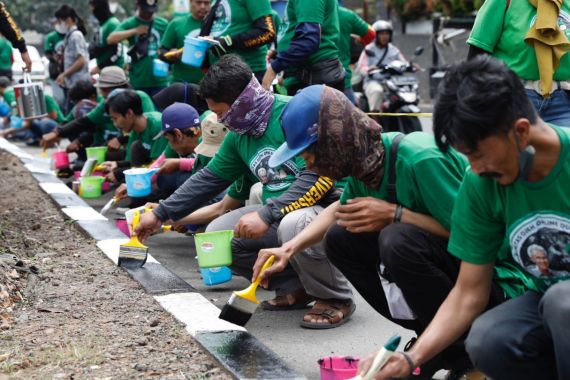Komunitas Ojol Dukung Ganjar Mengecat Separator Jalan di Cibinong - JPNN.COM