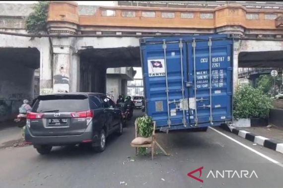 Truk Kontainer Bermuatan Karpet Tersangkut di Kolong Jembatan Rel Kereta Matraman - JPNN.COM