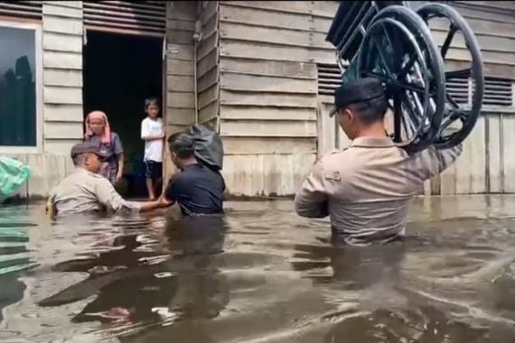 Beri Bantuan Kursi Roda ke Penyandang Disabilitas, Iptu Kaban Menerobos Banjir Setinggi Dada Orang Dewasa - JPNN.COM