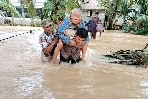 Anggota Polri Mengevakuasi 3 Lansia Terjebak Banjir di Rokan Hulu - JPNN.COM