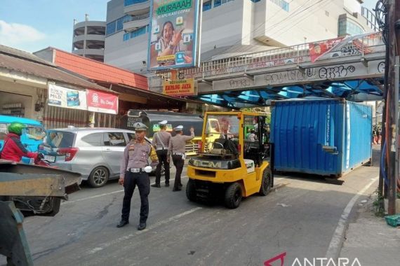 Truk Kontainer Tabrak Pembatas Jalan dan Tersangkut di Jembatan Perlintasan Kereta Bogor - JPNN.COM