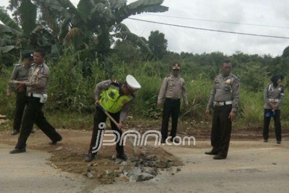 Lihatlah, Polisi Gotong Royong Memperbaiki Jalan - JPNN.COM