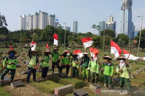 Petugas Bersihkan TPU Karet Bivak Sambil Bawa Bendera - JPNN.COM