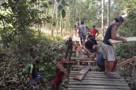 Bersama Warga, Prajurit Satgas Yonif 642 Perbaiki Jembatan yang Rusak Akibat Banjir - JPNN.COM
