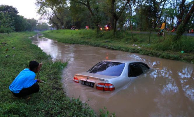 Pecah Ban, Mobil Sedan Mental ke Dalam Sungai